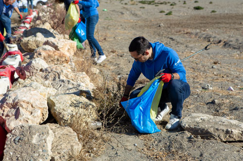 Persona recogiendo basura en playa de Málaga